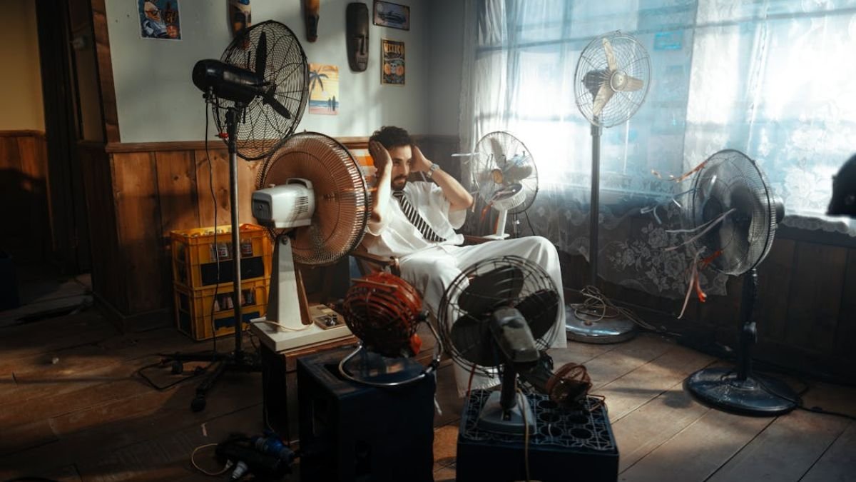 homem com varios ventiladores ao redor