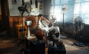 homem com varios ventiladores ao redor